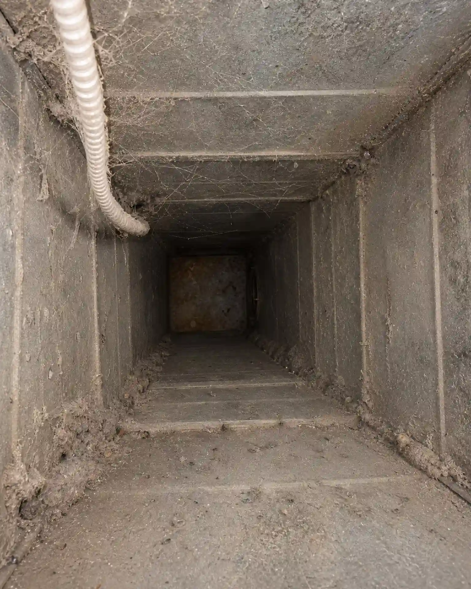 Grease-coated industrial exhaust ductwork inside an Ohio manufacturing plant before Service-Tech cleaning